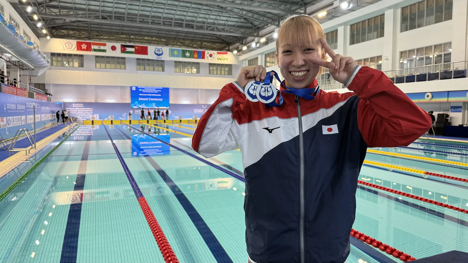 日本代表フィンスイミング上野愛美香選手がプールサイドでメダルを掲げる記念写真