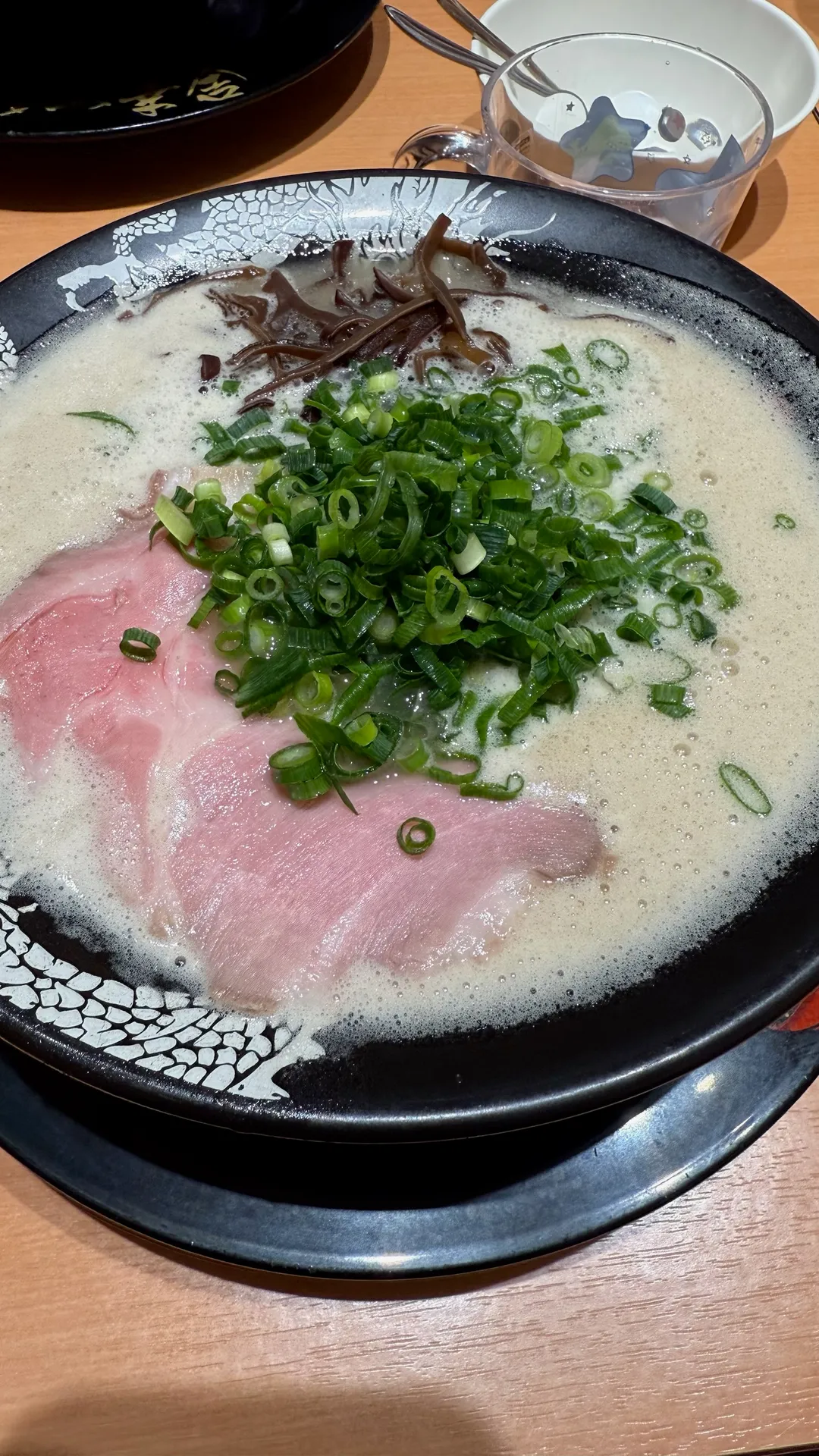 濃厚豚骨ラーメンにチャーシューとネギときくらげのトッピング