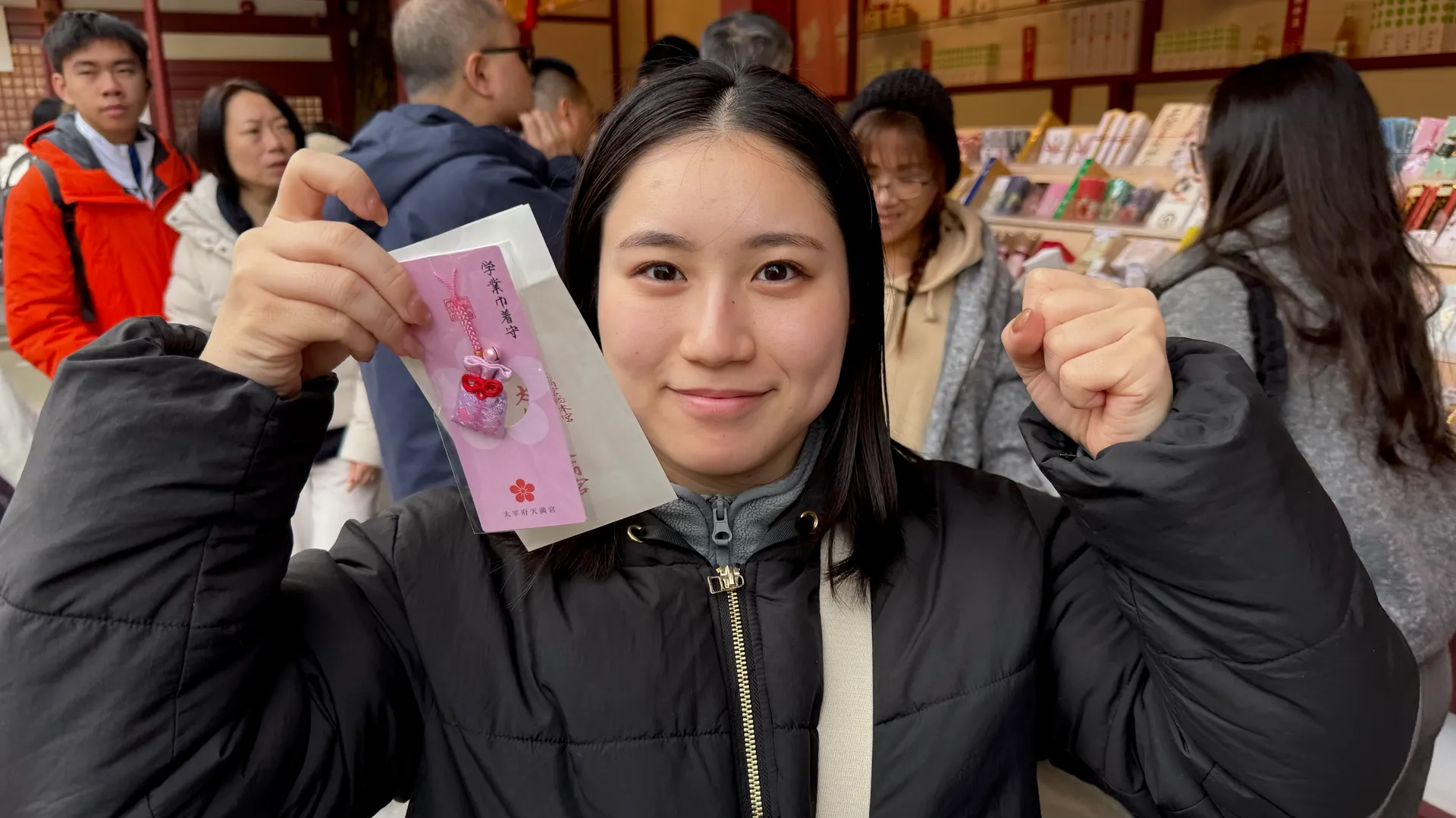 太宰府天満宮で学業巾着守を持ちガッツポーズするAQUA FinDメンバー