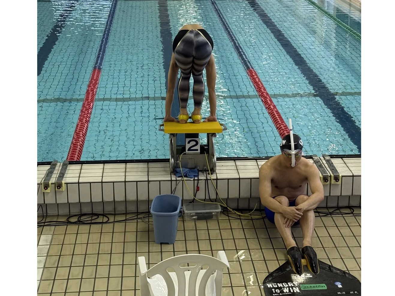 フィンスイミング選手がスタート台からリレーの飛び込み準備をする競技プールの様子