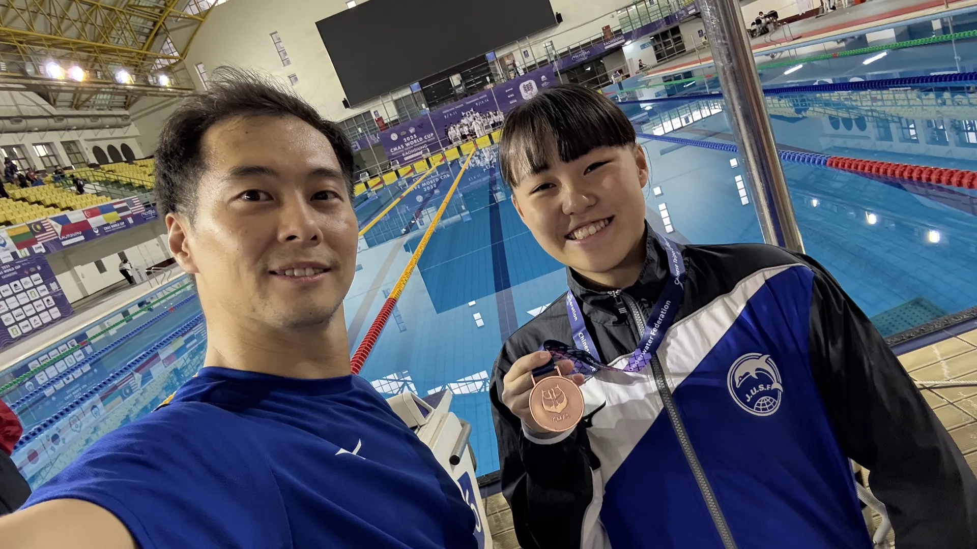 CMAS世界大会で銅メダルを獲得したAQUA FinDの選手とコーチがプールサイドで記念撮影