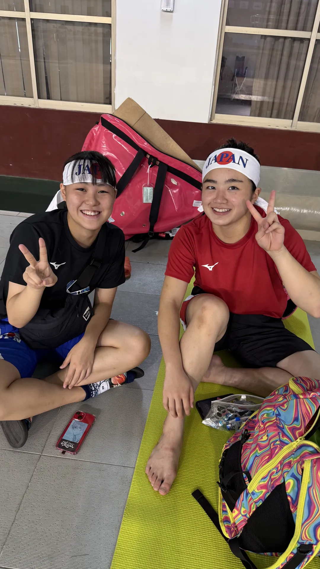 JAPANヘッドバンドを着けたMizunoウェアの日本代表フィンスイミング選手2名がピースサイン