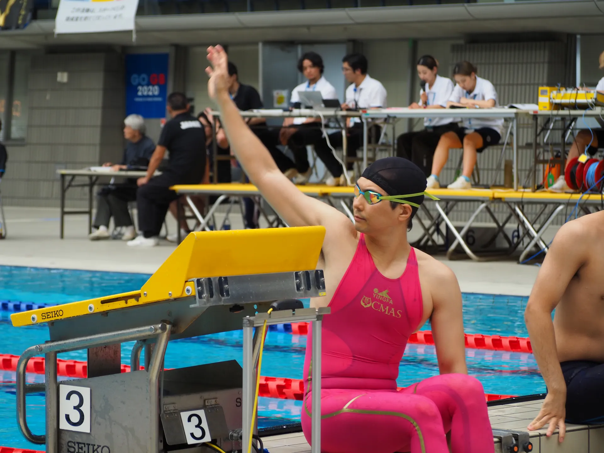 CMAS公式大会でスタート台横から手を挙げるピンクのフィンスイミング選手