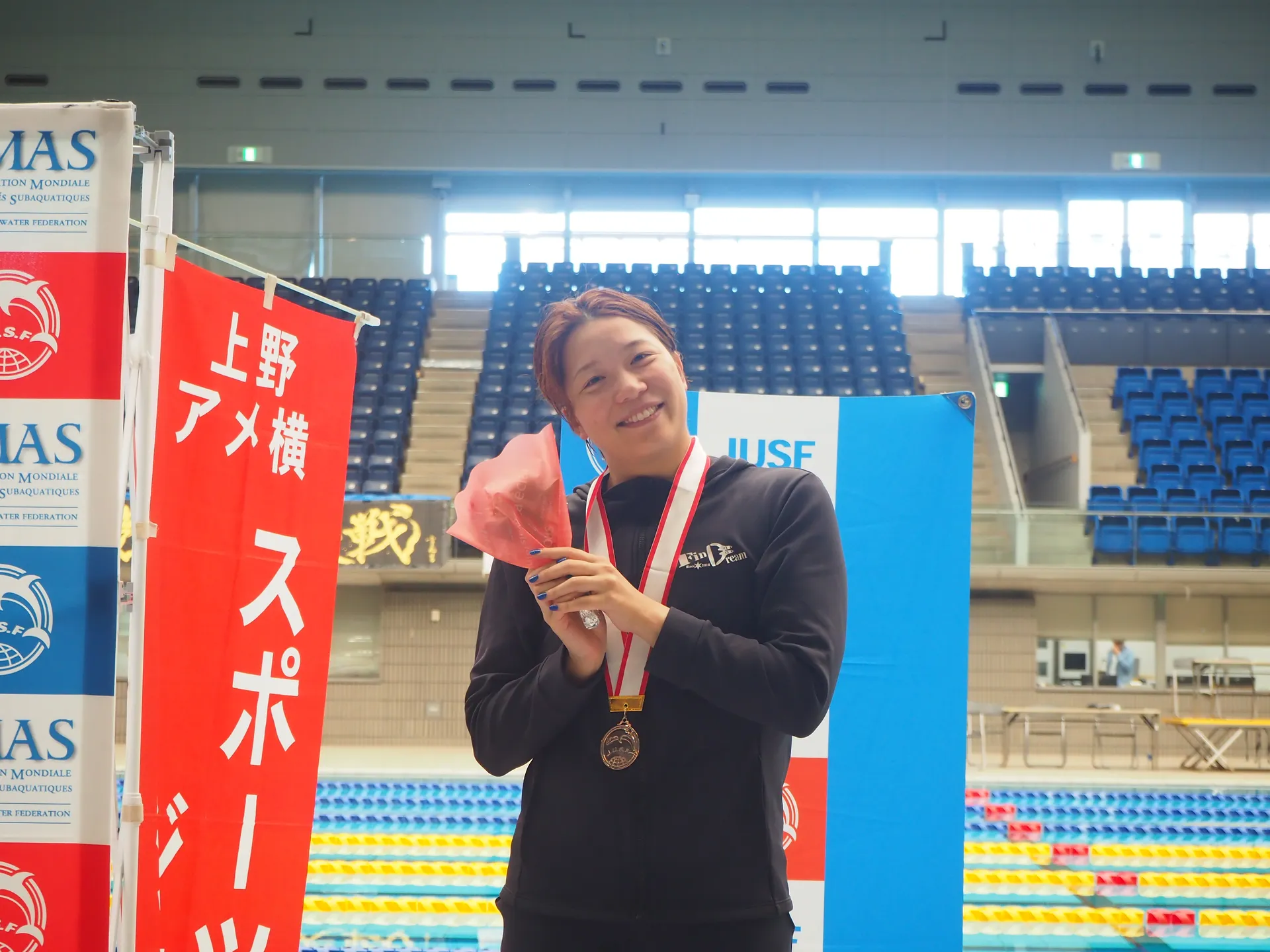 フィンスイミング大会でメダルと花束を持つAQUA FinDの女性選手