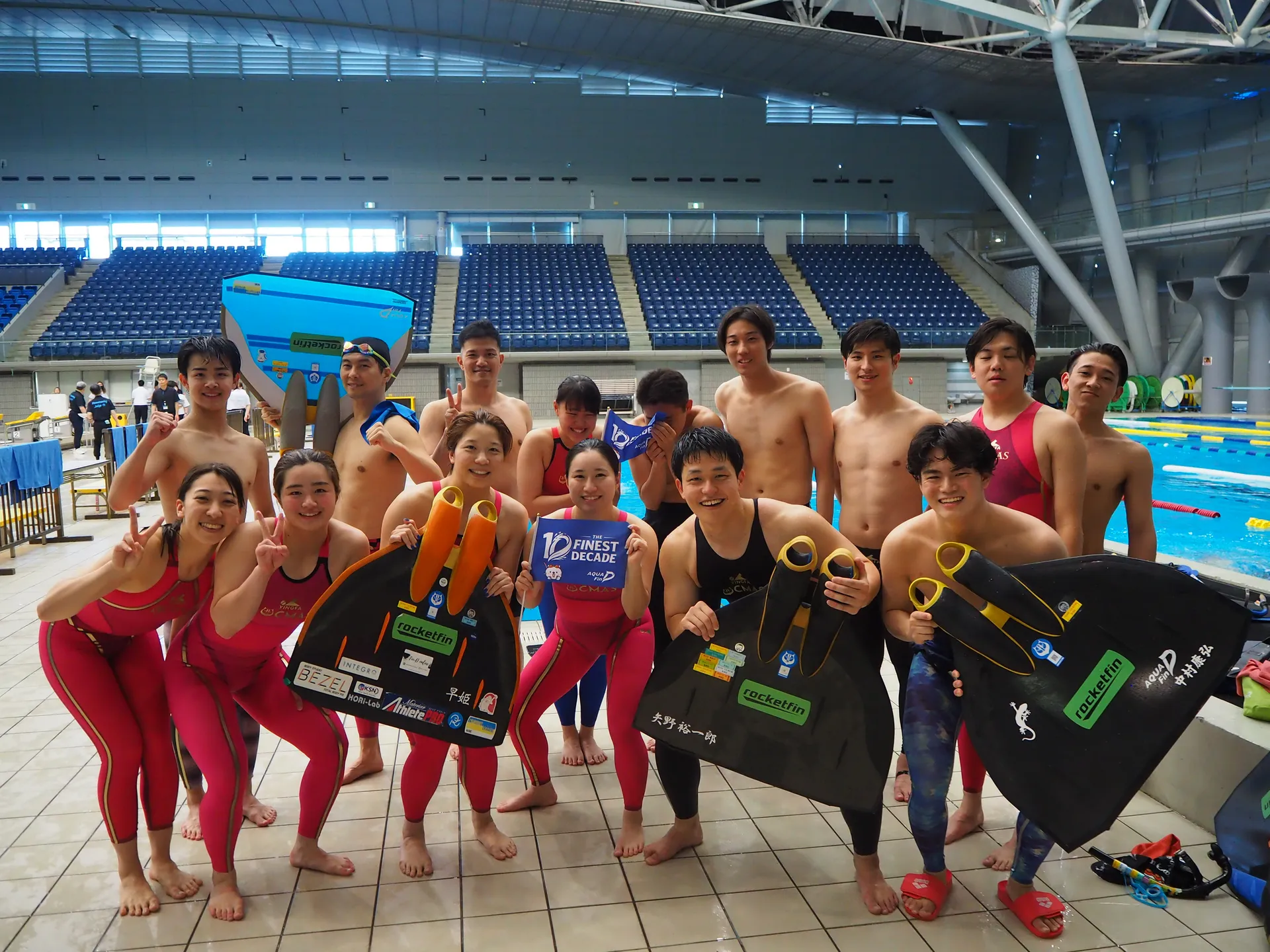 AQUA FinDフィンスイミングチームのメンバーがプールサイドでフィンを持って集合写真