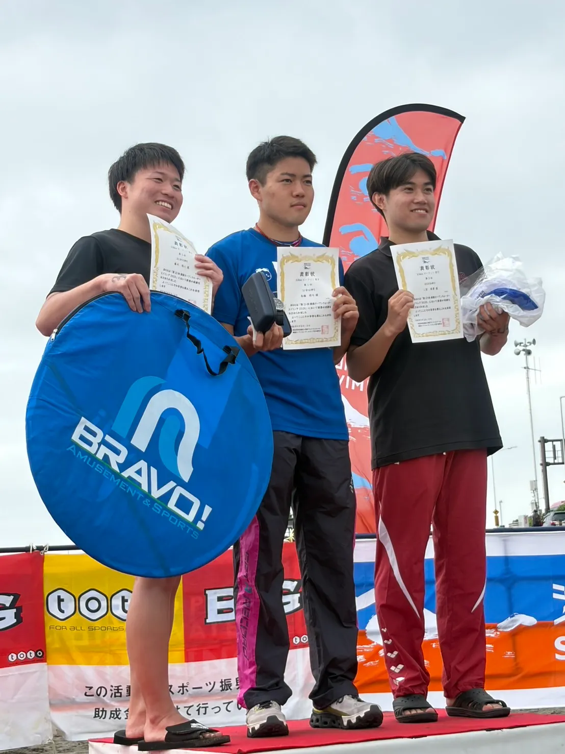 2.5kmビーフィン男子の上位3人が表彰状を持って並ぶ様子